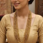 Elegant silverline gold seed bead necklace featuring multiple delicate strands arranged in a beautiful layered torsade style. A perfect statement jewelry piece for ethnic and modern outfits.